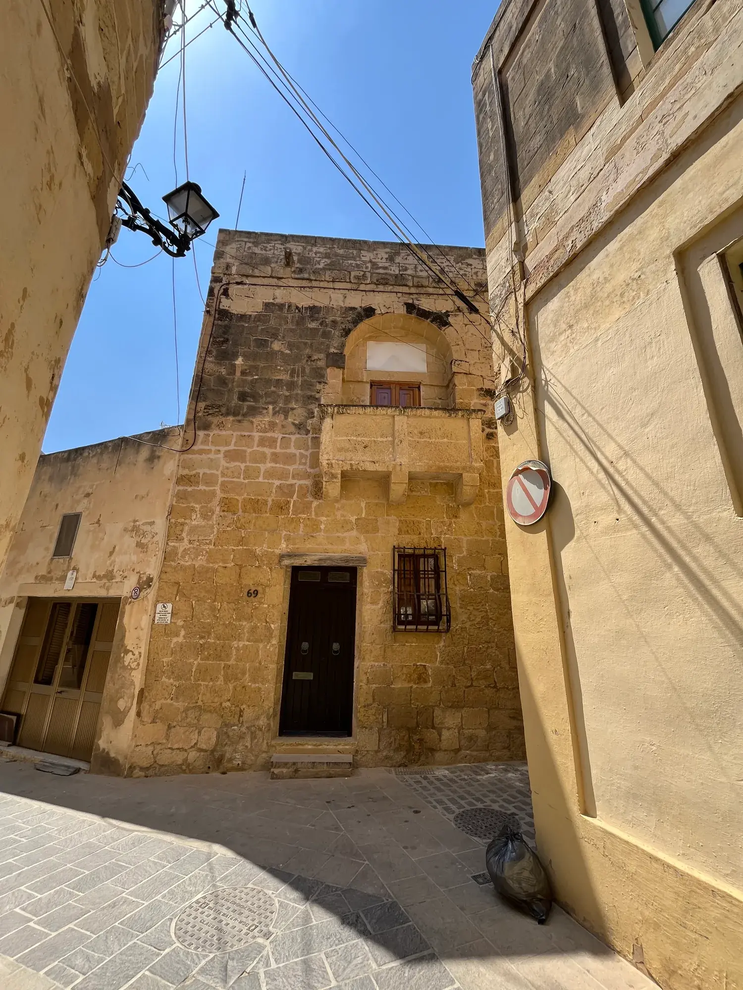 Golden limestone facade of Casa Barone on a narrow Gozo lane