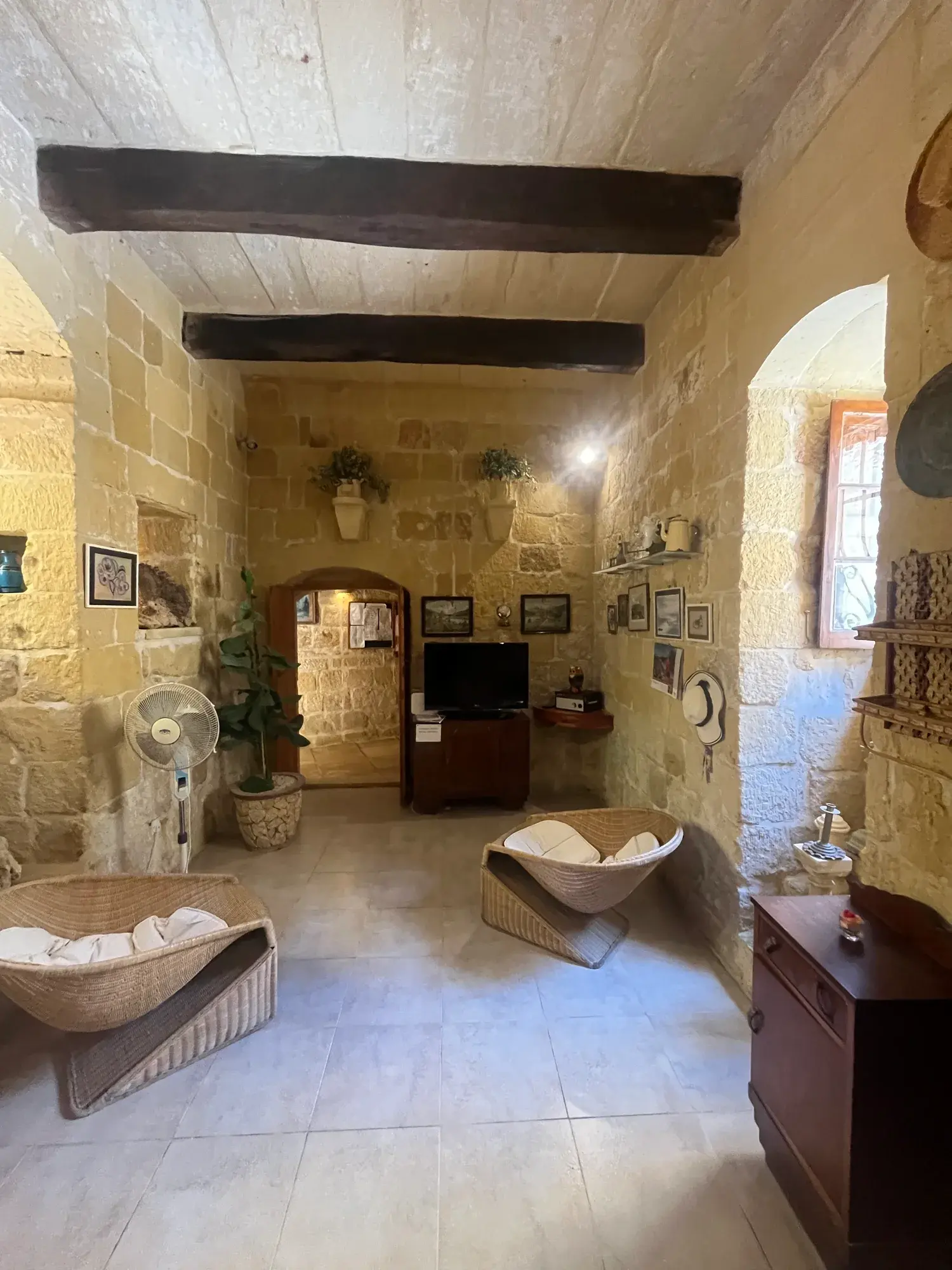 Casa Barone living room with exposed stone walls and dark timber ceiling beams