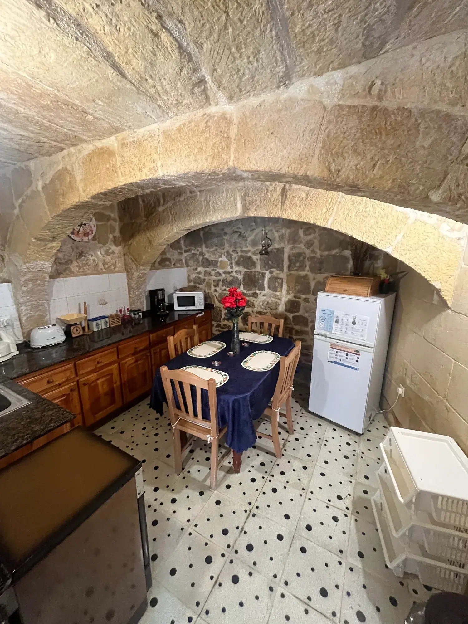 Kitchen and dining area beneath a limestone arch at Casa Barone