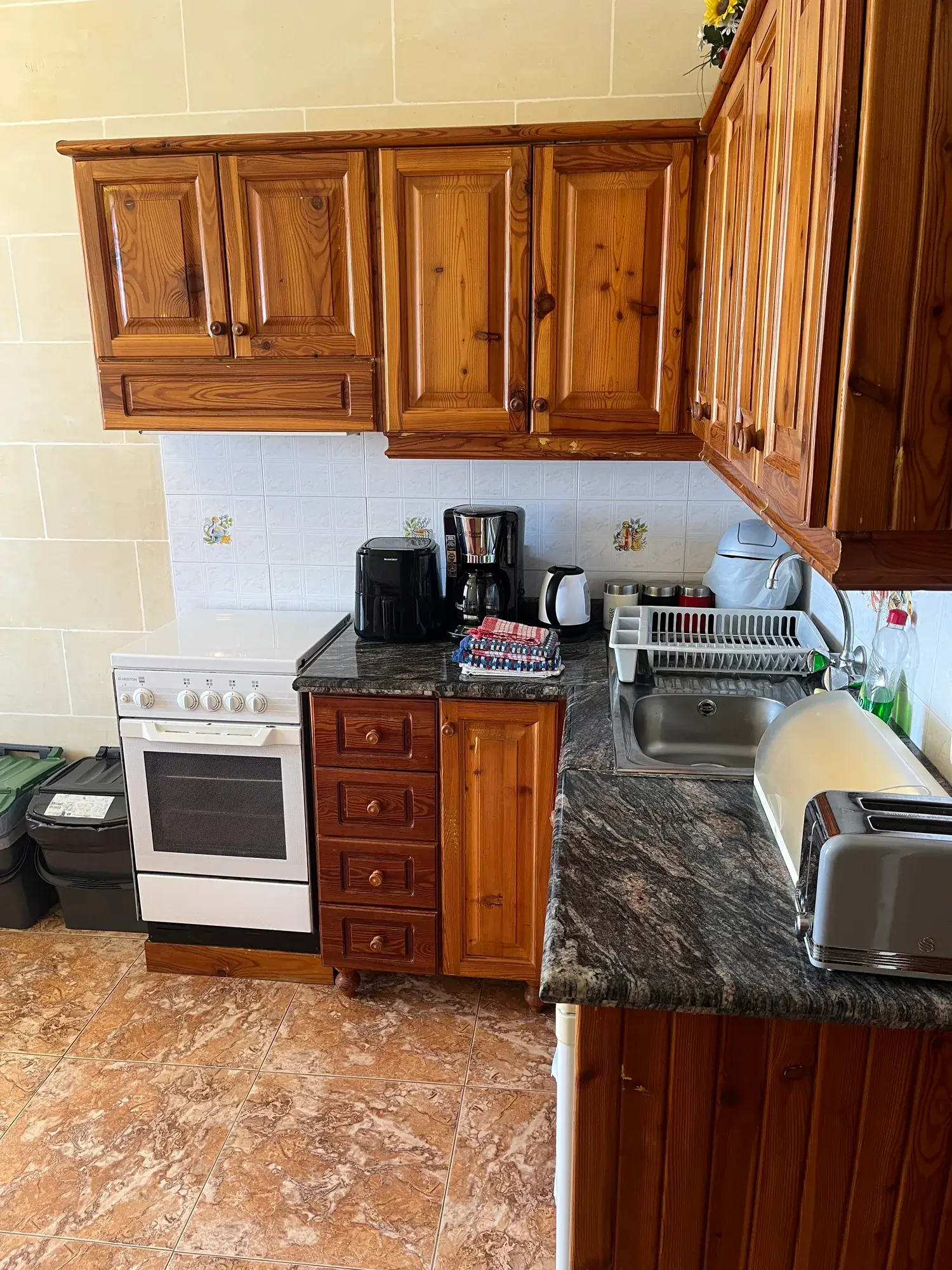 Wooden kitchen cupboards, cooker and sink at Sultana Apartment 4