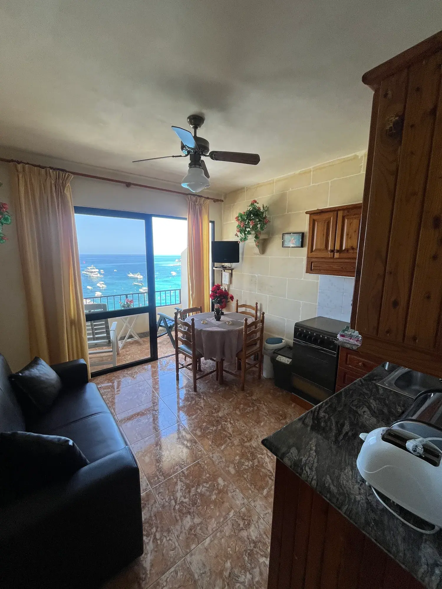 Sultana Apartment 5 living and dining area with the bay beyond the balcony