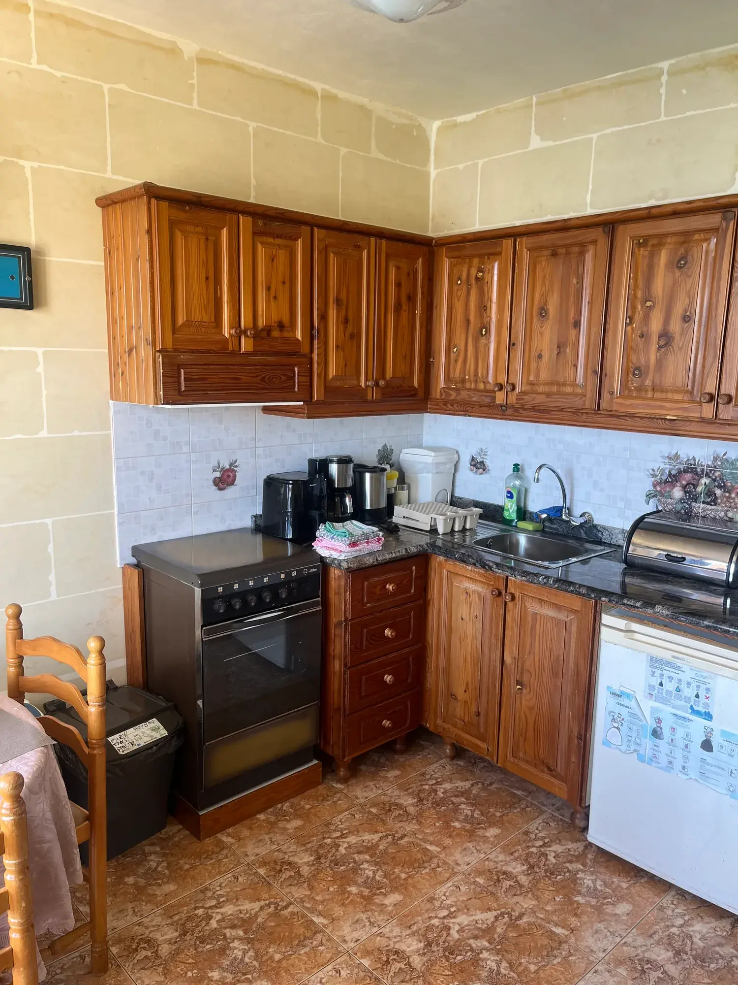 Kitchen with wooden cabinets and a cooker at Sultana Apartment 5