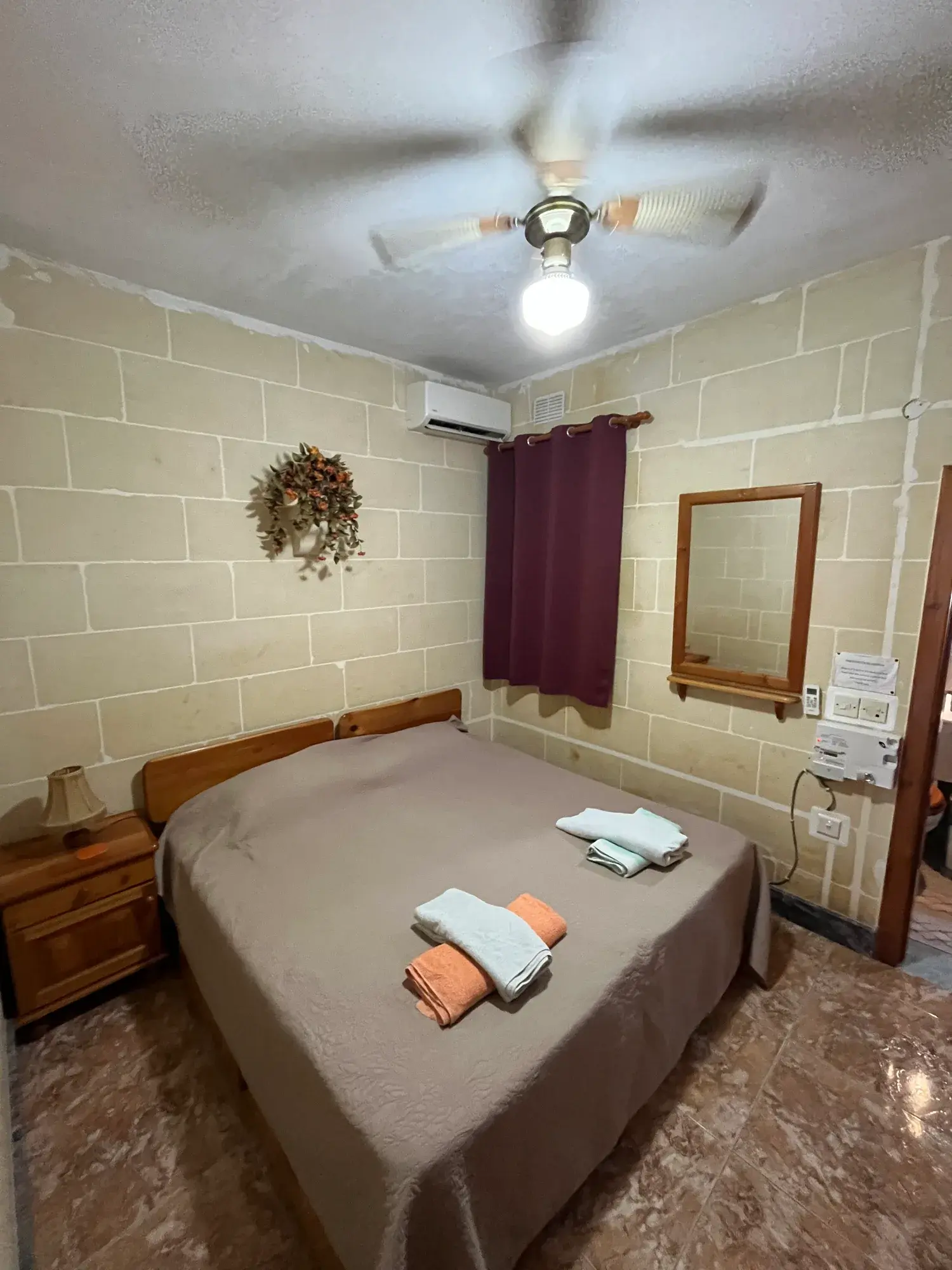 Double bedroom with limestone walls at Sultana Apartment 5