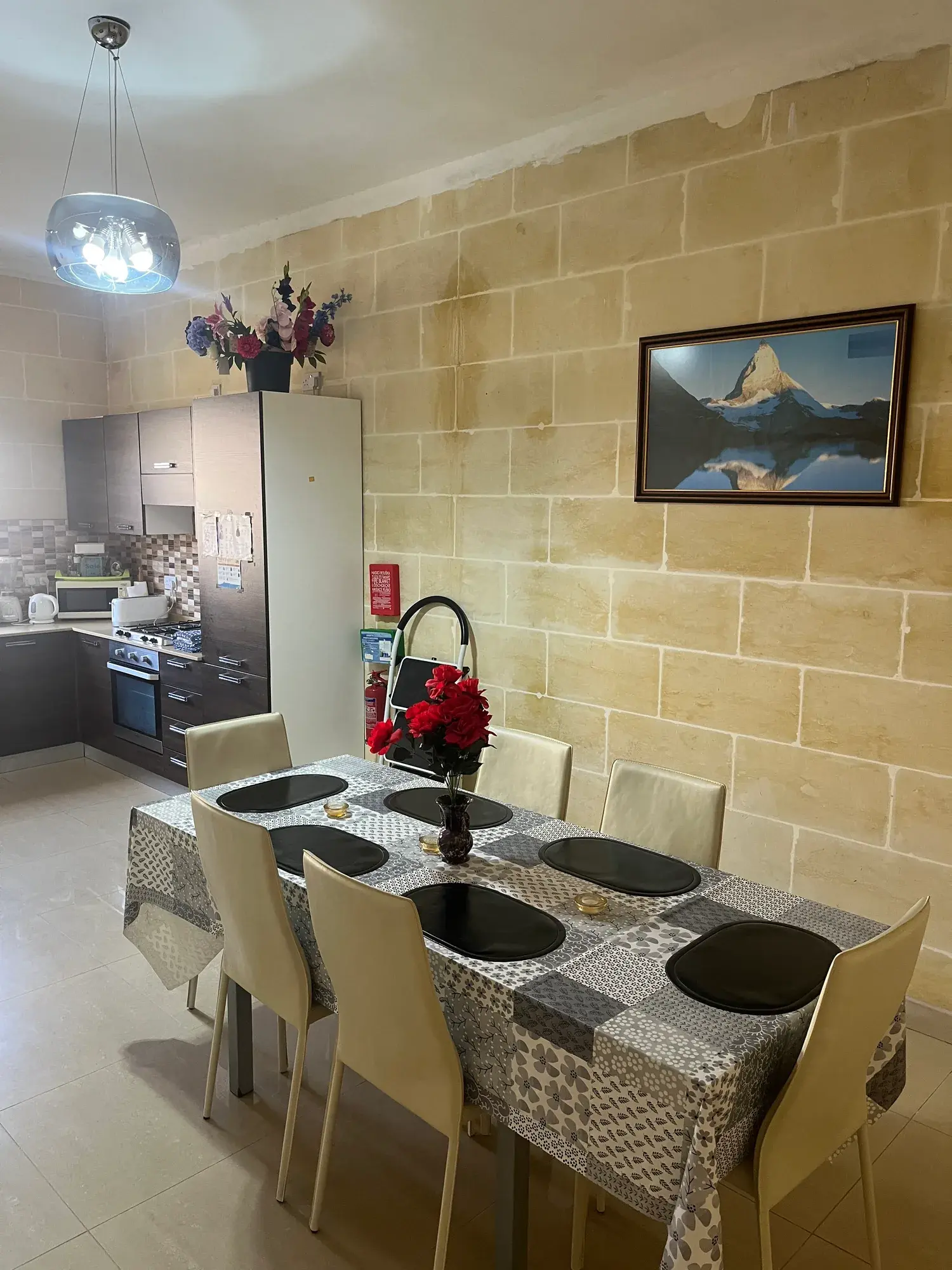 Kitchen and dining area with limestone walls at Vicmar Apartment 2