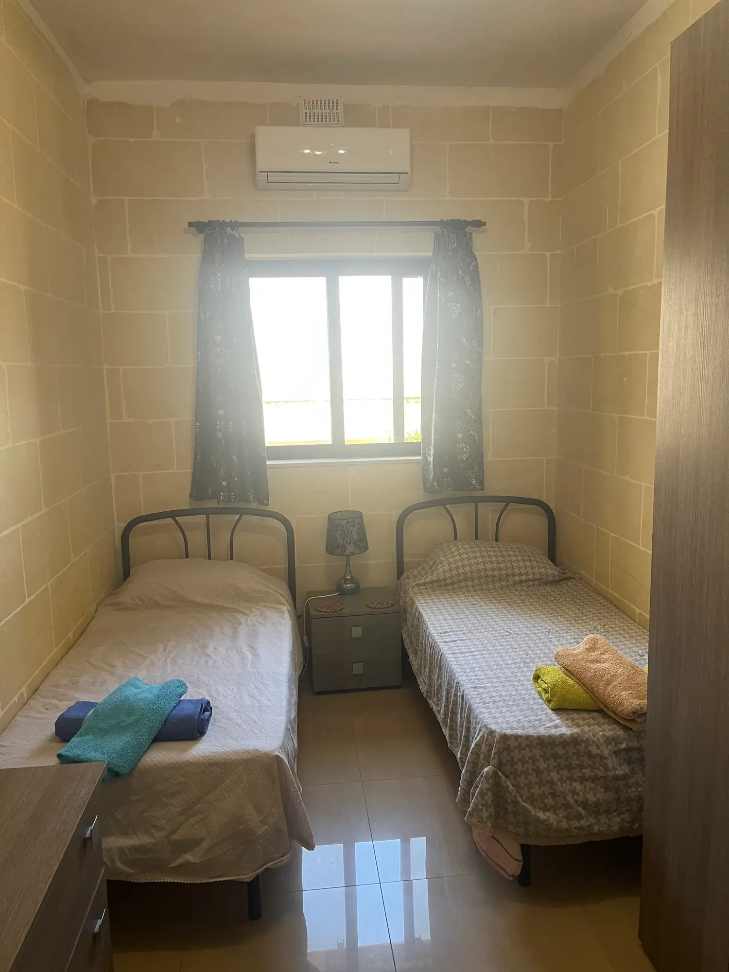 Twin bedroom with a bright window at Vicmar Apartment 2