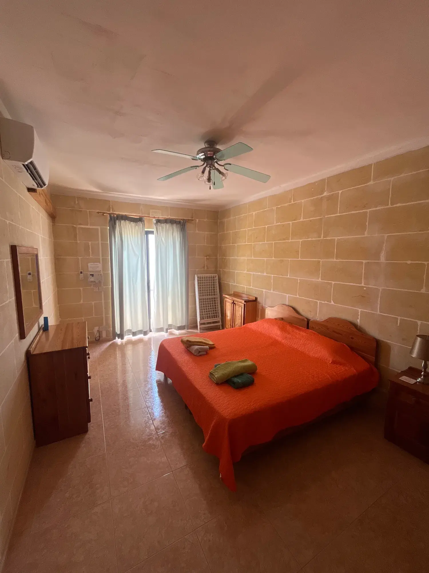 Double bedroom with an orange bedspread at Vicmar Penthouse